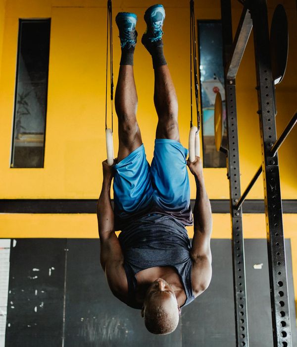 Man performing a controlled strength exercise in a modern, dark gym setting.